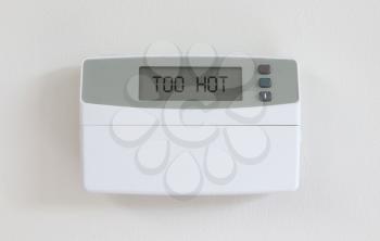 Vintage digital thermostat hanging on a white wall - Covert in dust - Too hot
