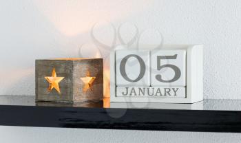 White block calendar present date 5 and month January on white wall background