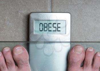 Closeup of man's feet on weight scale - Obese