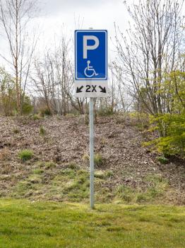 Disabled parking bay sign standing on the grass