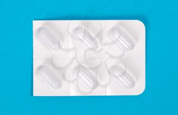 Pill strip isolated on blue background - Medicine concept