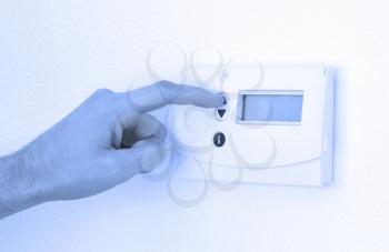 Vintage digital thermostat hanging on a white wall - Man adjusting