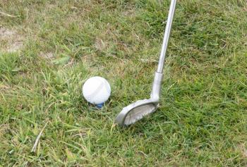 Golf ball on front of a driver at driving range