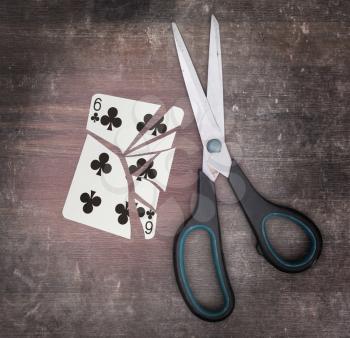 Concept of addiction, card with scissors, six of clubs