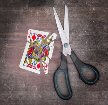 Concept of addiction, card with scissors, jack of diamond