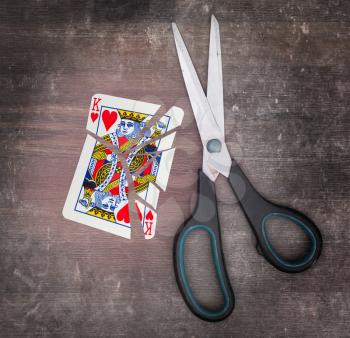 Concept of addiction, card with scissors, king of hearts