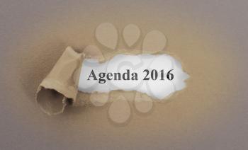 Text appearing behind torn brown envelop - Agenda 2016