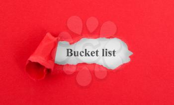 Text appearing behind torn red envelop - Bucket list