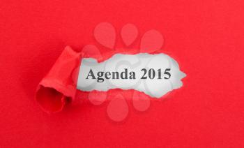 Text appearing behind torn red envelop - Agenda 2015