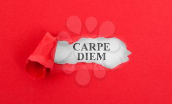 Text appearing behind torn red envelop - Carpe diem