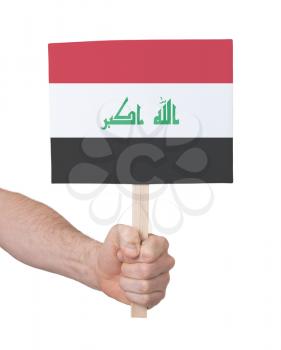 Hand holding small card, isolated on white - Flag of Iraq