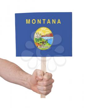 Hand holding small card, isolated on white - Flag of Montana