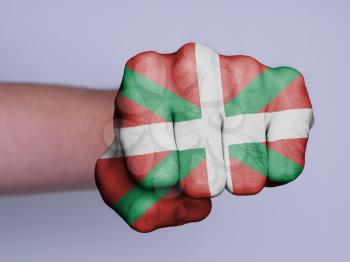 Very hairy knuckles from the fist of a man punching, flag of Basque Country