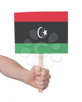 Hand holding small card, isolated on white - Flag of Libya