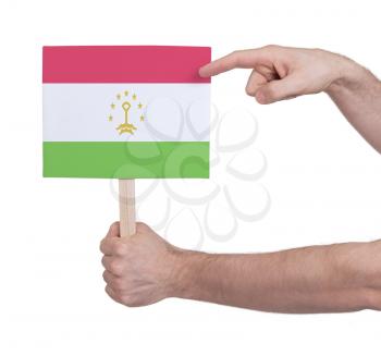 Hand holding small card, isolated on white - Flag of Tajikistan