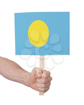 Hand holding small card, isolated on white - Flag of Palau