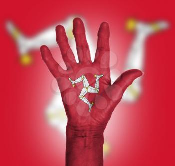 Palm of a woman hand, painted with flag of Isle of Man