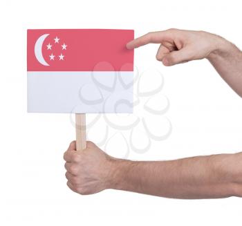 Hand holding small card, isolated on white - Flag of Singapore