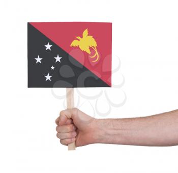 Hand holding small card, isolated on white - Flag of Papua New Guinea