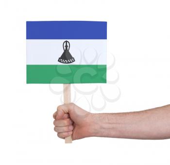 Hand holding small card, isolated on white - Flag of Lesotho