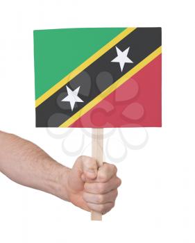 Hand holding small card, isolated on white - Flag of Saint Kitts and Nevis