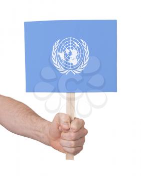 Hand holding small card, isolated on white - Flag of the UN