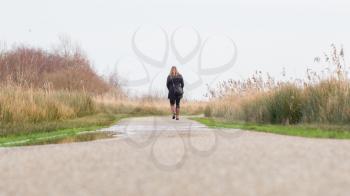 Young woman walking in a typical dutch landscape