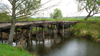 Image of old almost destroyed bridge across river