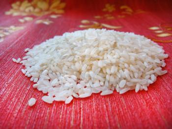 Handful of Rice scattered on a red background