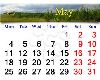 calendar for May of 2015 on the background of thunder storm clouds and pines