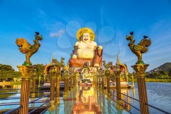 Giant smiling or happy buddha statue in Wat Plai Laem Temple, Samui, Thailand in a summer day