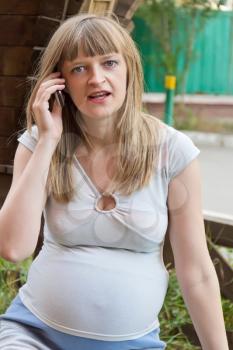 Image of pregnant woman talking by cellular