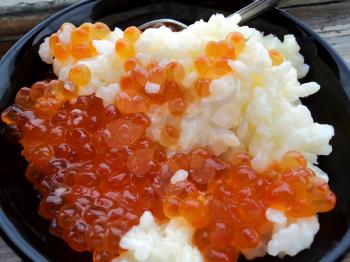 Rice with red caviar in black chalice
