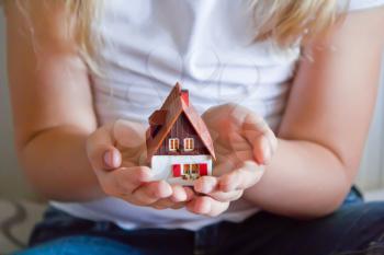 Photo of dollhouse in human hand on white background