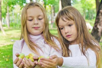 Photo of two girls with apples in summer