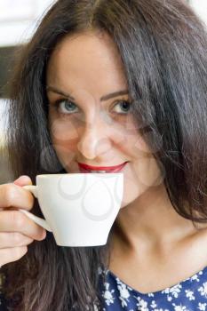 Photo of beautiful smiling brunette drinking coffee