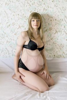 White pregnant blond woman in black underwear