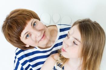 Portrait of happy mother and daughter near white wall
