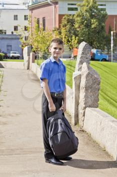 Brunette boy with school backpack in summer time