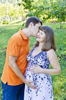 Couple awaiting baby in orange on green background