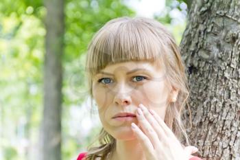 Portrait of thinking girl with blue eyes on green wood background