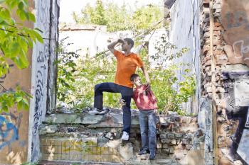 Father and teenager son are playing in ruins
