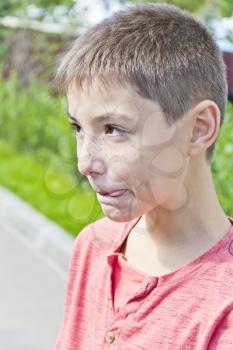 Vertical portrait of teenager boy with put out tongue
