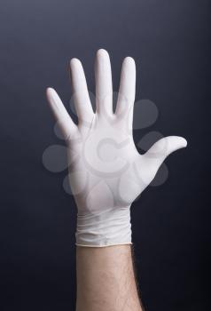 Female hands in latex gloves holding a syringe on dark background