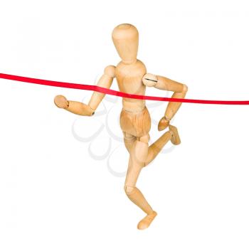 Wooden mannequin running through finishing line. Isolated on white.