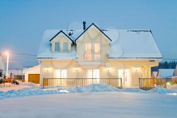 evening country house with electric light in winter