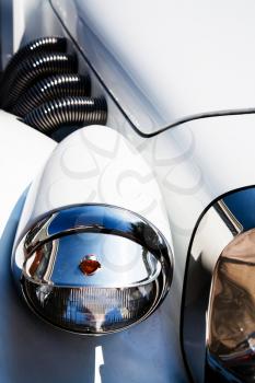 motor pipes and headlight of white retro car