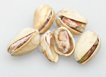 several salted pistachio nuts close up on white background