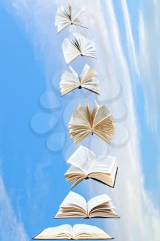 stack of books fly in blue sky with white cloud