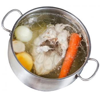 boiling of chicken soup with seasoning vegetables in steel pan isolated on white background
